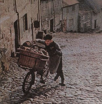 A young boy pushing a bike up a street